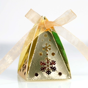 Detail van gouden piramide geschenkdoos met sneeuwvlok uitsnijding en zijden lint