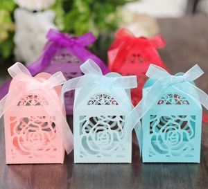 Detailed laser-cut rose hollow candy boxes with elegant silk ribbons in diverse colors