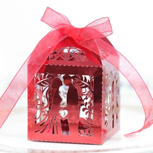 Detail of red metallic hollow candy box with laser-cut silhouette and organza ribbon