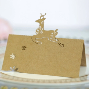 Laser-cut reindeer and snowflake place card on plate for rustic Christmas table settings