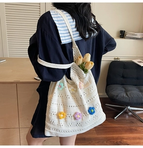 Dettaglio della borsa tote all'uncinetto bianca con fiori 3D colorati e trama traforata