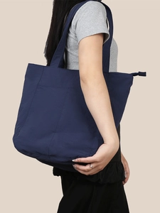 Dettaglio borsa tote in nylon blu scuro a spalla con grande capacità e cerniera lampo