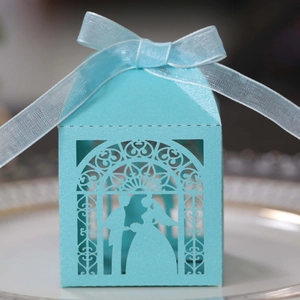 Detailed laser-cut hollow blue wedding candy box with elegant ribbon and silhouette