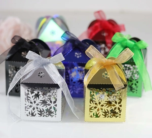 Détail de boîtes à bonbons ajourées flocon de neige avec finitions métalliques colorées