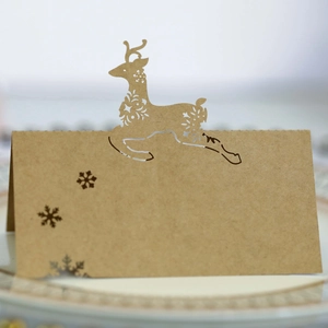Macro detail of laser-cut reindeer and snowflake patterns on kraft paper table cards