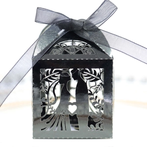 Detail of laser-cut black wedding favor box featuring bride and groom silhouette