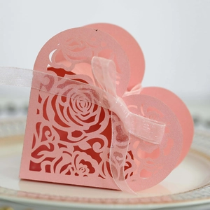 Detailed close-up of pink heart-shaped paper box with laser-cut roses and ribbon bow