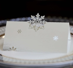Macro detail of laser-cut snowflake place card in pearlescent white for wedding tables