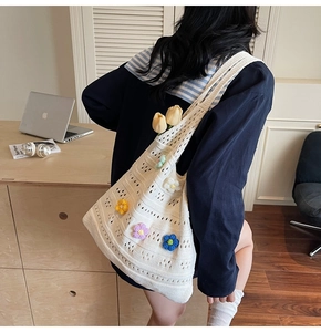 Dettaglio borsa shopper in maglia bianca con fiori colorati lavorati all'uncinetto