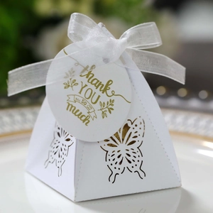 Detailed close-up of white butterfly laser-cut favor box with gold Thank You tag