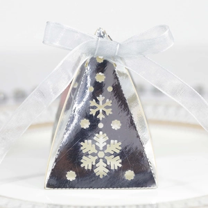 Macro-detail van zilveren piramide geschenkdoos met uitgesneden sneeuwvlok en organza lint