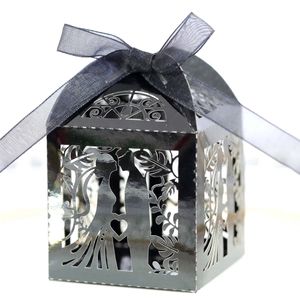 Detail view of black laser-cut wedding candy box with bride groom silhouettes and ribbon