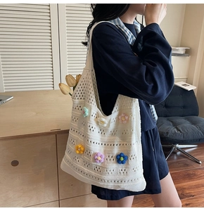 Detail view of a white crochet tote bag featuring vibrant 3D floral knitted patterns