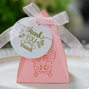 Close-up of pink pyramid favor box with laser-cut butterfly and thank you tag