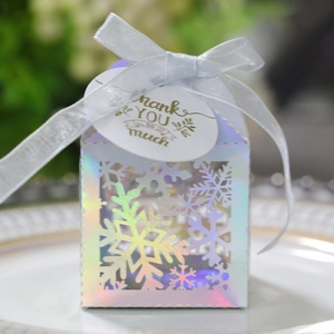 Détail de la boîte à bonbons flocon découpée au laser avec nœud blanc et étiquette