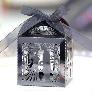 Detail of laser-cut black candy box with wedding silhouette and silk ribbon bow