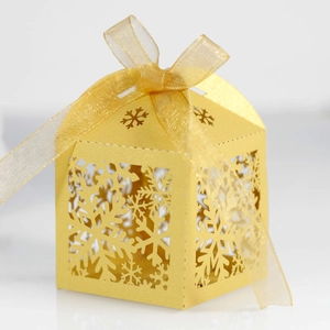 Macro shot of laser-cut snowflake hollow gift box with elegant organza ribbon bow