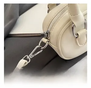 Detail of cream matte leather mini bowling bag with silver zipper and swivel hook