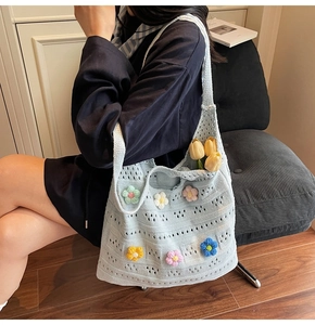 Dettaglio della borsa tote blu all'uncinetto con fiori 3D e motivo a traforo