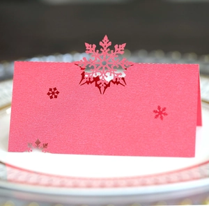 Macro detail of laser-cut snowflake place card in pearl red paper for Christmas dinner
