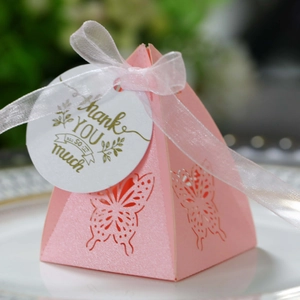 Detailed macro view of laser-cut butterfly on pink pearlescent pyramid gift box