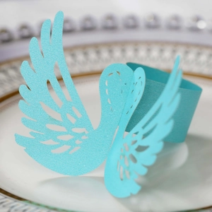 Detail of light blue glitter swan napkin ring with laser-cut hollow feather patterns