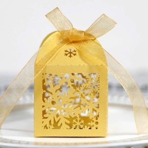 Detail of laser-cut gold snowflake gift box with matching sheer ribbon bow decoration