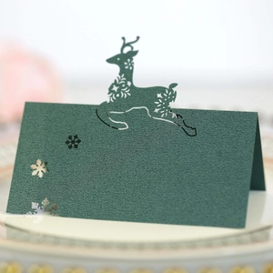 Detail of laser-cut reindeer and snowflake patterns on dark green pearlescent cardstock