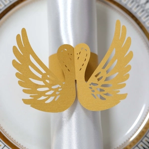 Macro shot of gold laser-cut swan napkin rings for wedding table setting and banquet decor