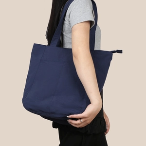Dettaglio della borsa tote in nylon impermeabile blu scuro con tracolla e cerniera