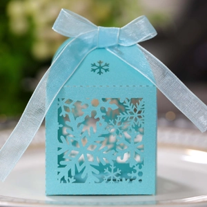 Detail of light blue laser-cut snowflake gift box with matching organza ribbon bow