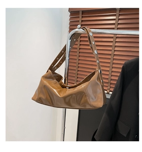 Detailed macro view of brown wax leather shoulder bag with round silver metal studs