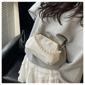 Detail view of a vintage white pearl strap bag featuring elegant butterfly embroidery