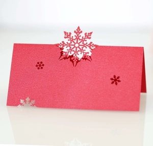 Macro detail of red snowflake laser-cut place card with elegant paper texture