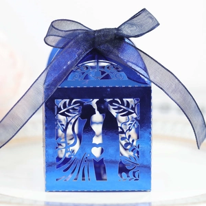 Detail of laser-cut heart candy box with romantic silhouette and blue organza bow