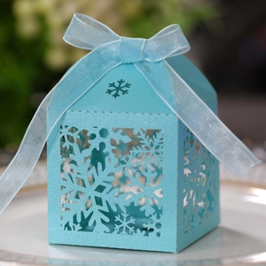 Macro detail of laser-cut snowflake hollow gift box in blue with organza ribbon bow
