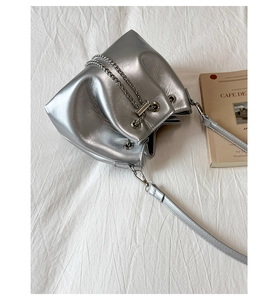 Détail du sac seau argenté métallisé avec cordon chaîne et texture de qualité