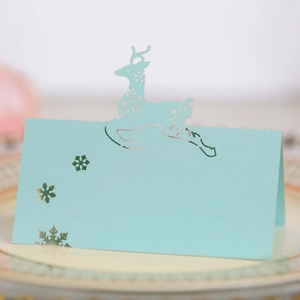 Macro view of laser-cut reindeer and snowflake seat cards with pearlescent finish