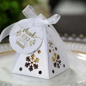Macro-opname van witte sneeuwvlok geschenkdoos met parelmoerglans en bedankkaartje
