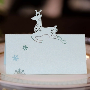 Macro detail of laser-cut reindeer and snowflake on pearlescent light blue place card