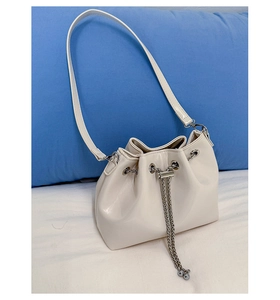 Gros plan sur le sac seau blanc cassé avec cordon en chaîne et cuir PU de qualité