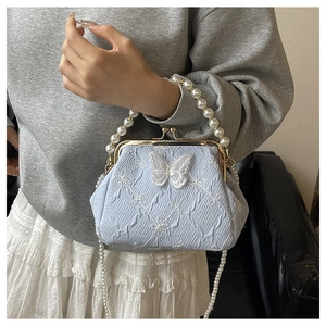Detail of light blue pleated bag with lace butterfly and elegant pearl handle straps
