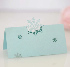 Macro shot of light blue laser-cut snowflake place card made of premium pearlescent paper