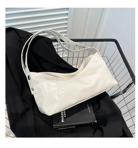 Close-up of off-white faux leather hobo bag with silver metallic eyelet strap detail