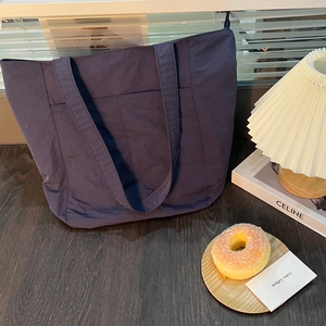 Dettaglio della borsa tote in nylon blu navy con tasche frontali e superficie strutturata