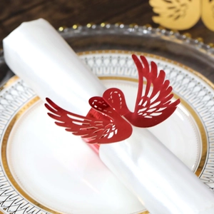 Detailed laser-cut red bird napkin ring on a white napkin and gold-rimmed ceramic plate
