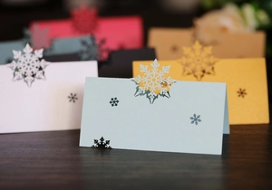 Detailed laser-cut snowflake place cards in assorted pearlescent colors for weddings