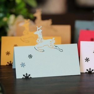 Laser-cut reindeer place cards in light blue and yellow for Christmas table decor