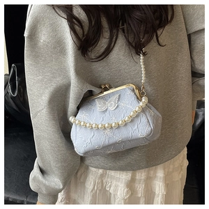 Detail of light blue vintage bag with butterfly embroidery and pearl chain strap