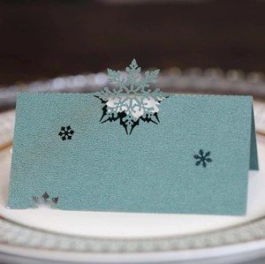 Macro shot of dark green laser-cut snowflake place card with elegant shimmer texture